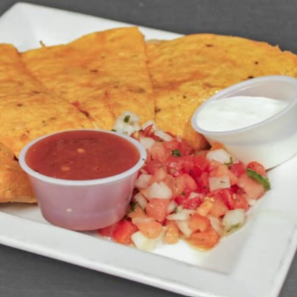 Pines Bar and Grill quesadillas with salsa, pico de gallo, and sour cream on a white plate.