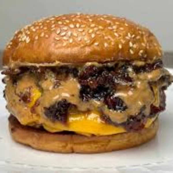A Pines Bar and Grill burger with melted cheese, bacon jam, and peanut butter sauce.